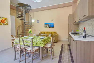 a kitchen and dining room with a table and chairs at Casa Maria Stella Scopello in Scopello