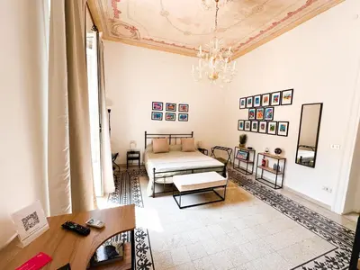 a living room with a bed and a chandelier at Da Cosimo U pitturi in Palermo