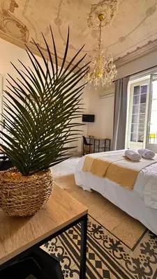 a bedroom with a bed and a potted plant on a table at Da Cosimo U pitturi in Palermo