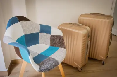 a chair with a blanket next to a suitcase at Scalini holiday in Castellammare del Golfo