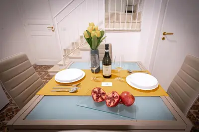 a dining room table with plates and wine glasses at Scalini holiday in Castellammare del Golfo