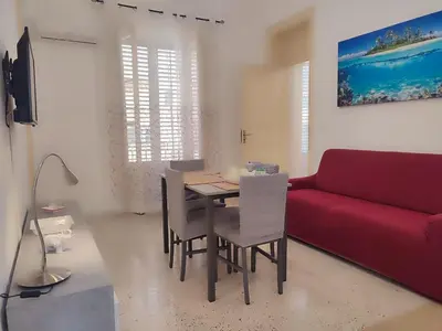 a living room with a table and a red couch at Politeama my Suite in Palermo
