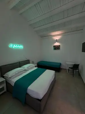 a hotel room with a bed and a sign on the wall at Il falchetto in Palermo