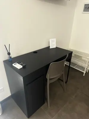 a black desk with a chair in a room at Il falchetto in Palermo
