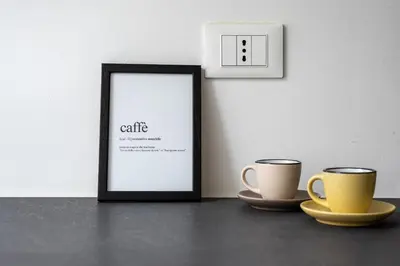 two cups sitting on a table next to a picture frame at Lumar Sicilia - Magione in Palermo