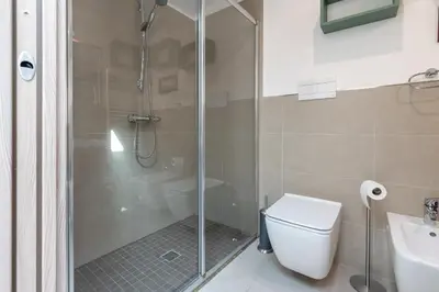 a bathroom with a shower and a toilet and a sink at Lumar Sicilia - Quaroni in Palermo