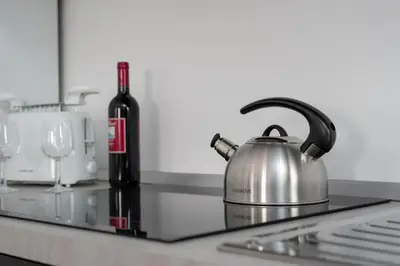 a tea kettle and a bottle of wine on a kitchen counter at Lumar Sicilia - Quaroni in Palermo
