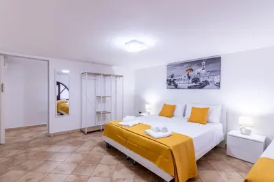 a bedroom with a large white bed and yellow pillows at Lumar Sicilia - Cattedrale in Palermo
