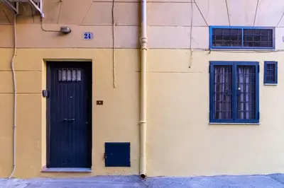 a building with a blue door and two windows at Lumar Sicilia - Cattedrale in Palermo