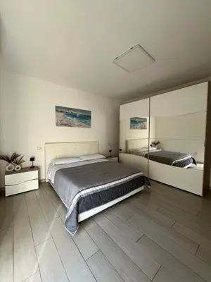 a bedroom with a large bed and a mirror at Nela Appartament in Bagheria