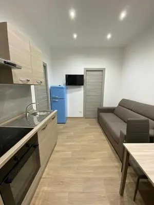 a kitchen and living room with a couch and a table at Casa Nonna Lina in Isola delle Femmine