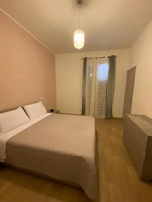a bedroom with a white bed and a window at Casa Nonna Lina in Isola delle Femmine