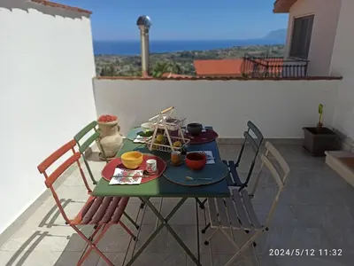 a table and chairs on a balcony with a view at Mediterraneo Rooms in Castellammare del Golfo