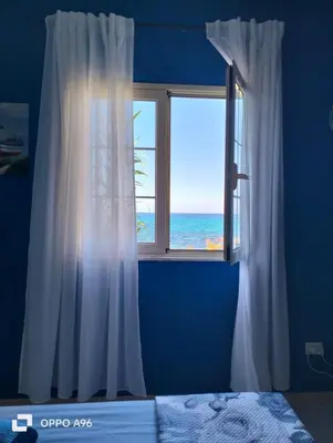 a bedroom with a window with a view of the ocean at LA TERRAZZA SUL MARE camera fronte mare&vicino aereoporto SICILIAN VINTAGE STYLE SEASIDE ROOM in Cinisi
