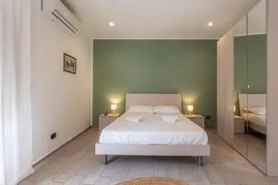 a bedroom with a white bed and a mirror at Venere - Alle Spalle del Teatro Massimo in Palermo