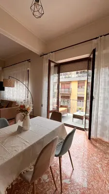 a dining room with a table and chairs and a living room at Kasa Stabile in Palermo