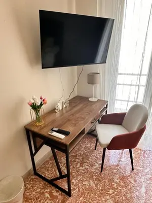 a desk with a chair and a television on a wall at Kasa Stabile in Palermo
