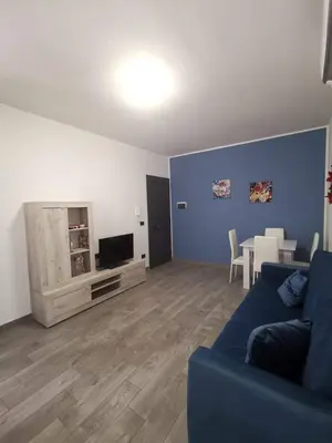 a living room with a blue couch and a tv at Casa Vacanze il Cortile in Casteldaccia