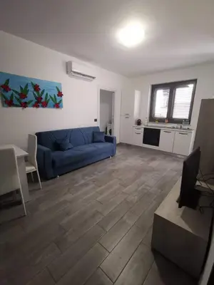 a living room with a blue couch and a table at Casa Vacanze il Cortile in Casteldaccia