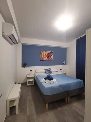 a bedroom with a bed with a blue wall at Casa Vacanze il Cortile in Casteldaccia
