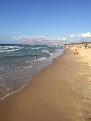 a group of people swimming in the ocean on a beach at Profumo di Mare 2 in Alcamo Marina