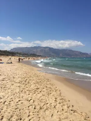a beach with people on the sand and the ocean at Profumo di Mare 2 in Alcamo Marina