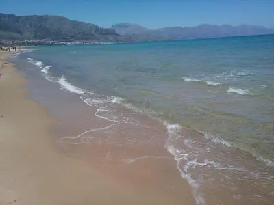 a beach with the ocean and mountains in the background at Profumo di Mare 2 in Alcamo Marina