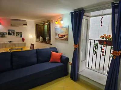 a living room with a blue couch and a window at Casa Pretoria in Palermo