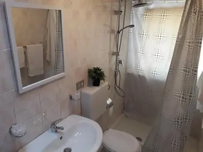 a bathroom with a toilet and a sink and a shower at La casa di Ross in Casteldaccia