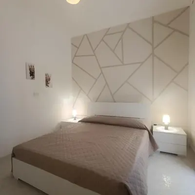 a bedroom with a large bed with two night stands at Sole e mare 1 in Isola delle Femmine