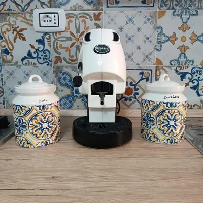 a white coffee maker sitting on a counter next to two cups at Sole e mare 1 in Isola delle Femmine