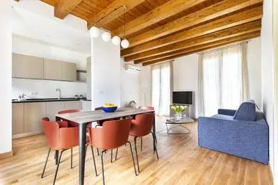a dining room and living room with a table and chairs at Cassari Maisons in Palermo