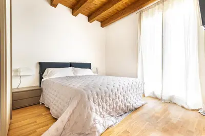 a white bedroom with a bed and a window at Cassari Maisons in Palermo