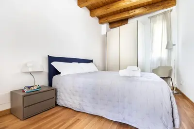 a bedroom with a white bed and a wooden ceiling at Cassari Maisons in Palermo