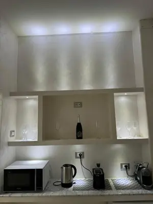a kitchen with a microwave and wine glasses on a counter at Karma House in Palermo