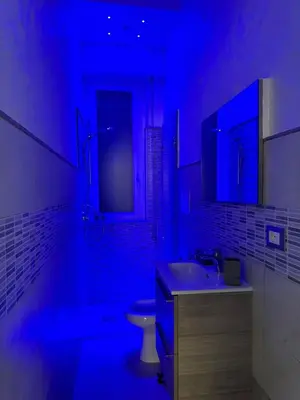 a bathroom with a sink and a toilet in a blue light at Karma House in Palermo