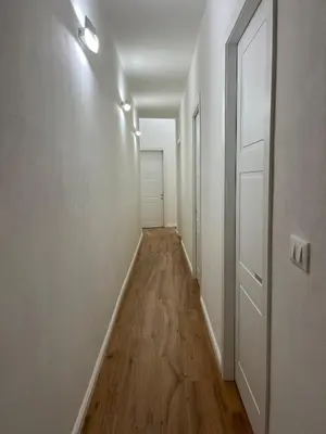 an empty hallway with white walls and wooden floors at Aurora Center City - Rooms in Palermo