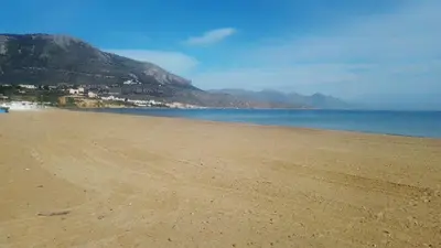 an empty beach with mountains in the background at Casa Marina con vista sul castello in Castellammare del Golfo