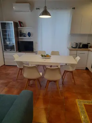 a white table and chairs in a room with a kitchen at Casa Kyla in Palermo