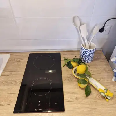 a counter top with a black stove with a lemon and a knife at Casa Kyla in Palermo