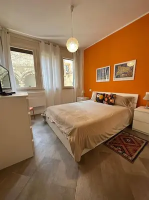 a bedroom with orange walls and a large bed at coppola home in Palermo