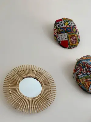 a wooden plate with a mirror and two ties at coppola home in Palermo