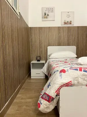 a bedroom with a bed and a wooden wall at FM Home Stadio Renzo Barbera in Palermo