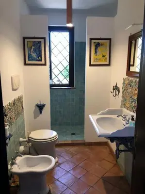 a bathroom with two sinks and a toilet and a tub at Villa Rubino ai Colli in Palermo