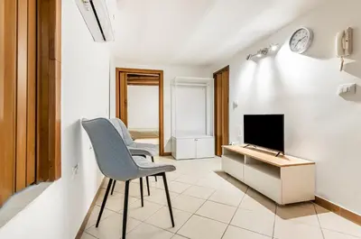 a living room with a chair and a television at GuestHost - Central Station Modern Apartment with Balconies x8 in Palermo