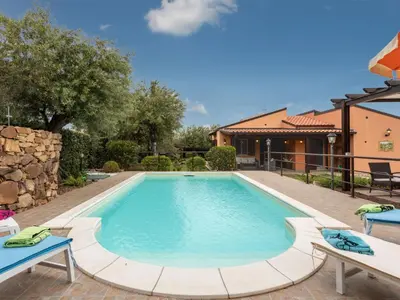 a swimming pool in a yard with two chairs at Villa Olivella by Interhome in Cefalù