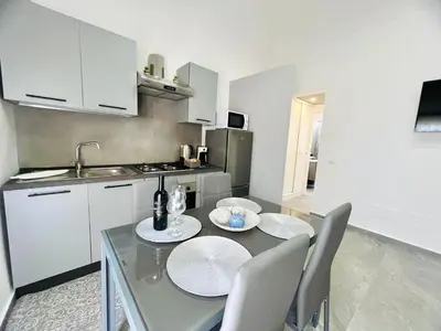 a kitchen with a table and chairs in a kitchen at Soevi Appartamenti in Carini