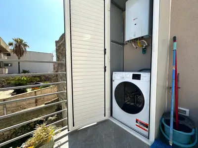 a washer and dryer on a balcony of a house at Soevi Appartamenti in Carini