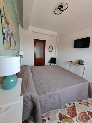 a bedroom with a bed and a table with a lamp at Skyline Palermo in Palermo