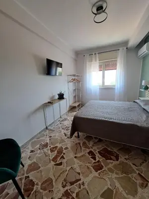 a bedroom with a bed and a chair and a window at Skyline Palermo in Palermo